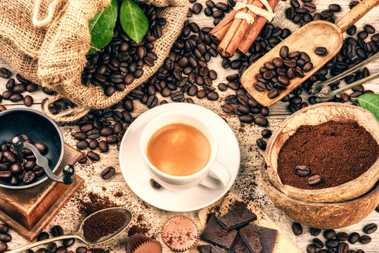 Fototapeta Cup of hot black coffee with old wooden mill grinder and burlap