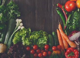 Border of fresh vegetables on wooden background with copy space
