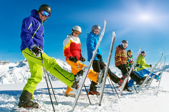 Gruppe Skifahrer in der Reihe mit einem Ski hoch
