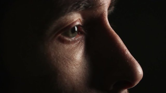 man looking in a dark room. Eyes closeup