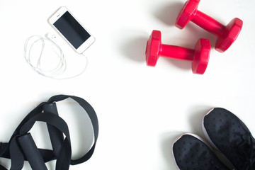 Flat lay of cellphone, red dumbbells and sport equipment on whit