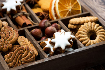 wooden box with Christmas sweets and spices on wooden background