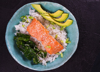 Salmon with spinach and avocado. Rice as a garnish. View from above, top studio shot