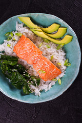 Salmon with spinach and avocado. Rice as a garnish. View from above, top studio shot