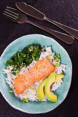 Salmon with spinach and avocado. Rice as a garnish. View from above, top studio shot