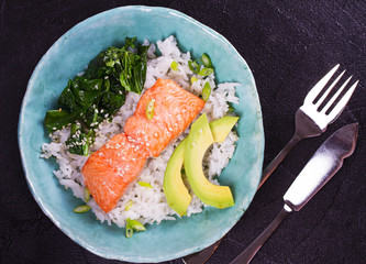 Salmon with spinach and avocado. Rice as a garnish. View from above, top studio shot