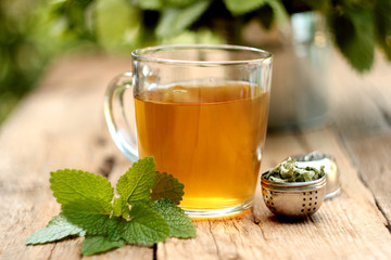 A cup of melissa tea on wooden background
