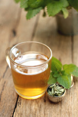 A cup of melissa tea on wooden background
