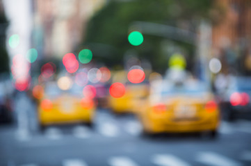 Yellow taxis crowd the streets of New York City at dusk in a defocus abstract scene of green traffic lights and red tail lights