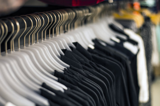 Black chlotes hanging on hangers at the store