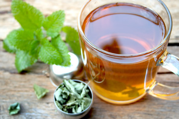 A cup of melissa tea on wooden background
