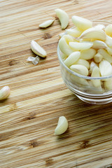 Pile of peeled garlic on wooden table