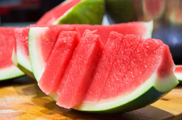 Watermelon without seeds cut in slices on wooden table