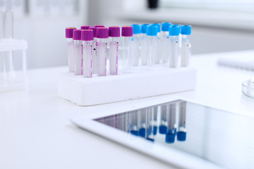 Research laboratory working space. Test tubes and tablet PC are lying at the table. Medical equipment. Blood test