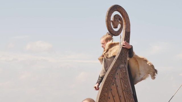 Mad vikings on the Drakkar on the river shore