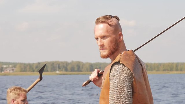 Mad vikings on the Drakkar on the river shore