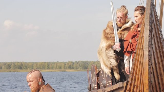 Mad vikings on the Drakkar on the river shore