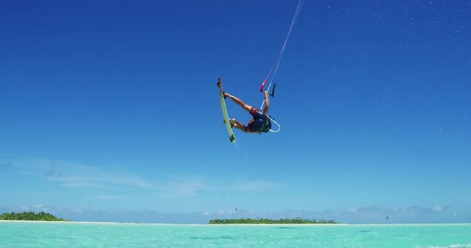 Young man kitesurfing in tropical blue ocean, extreme sport slow motion