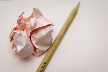 crumpled papers and pencil on desk