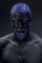 Man painted in black color with rhinestones hair, beard and eyebrows