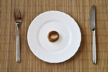 Bagel lies on a white saucer - diet breakfast