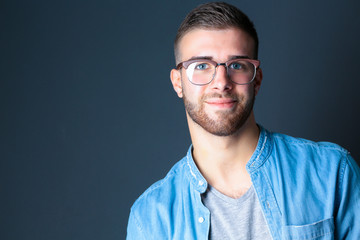 Obraz premium Portrait of a happy casual man standing isolated on a dark background