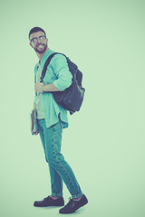 A male student with a school bag holding books isolated on white background