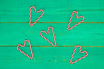 Candy cane shaped hearts on bright green background