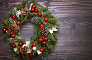 Christmas wreath and ribbon bow on wooden background