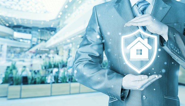 House protection and insurance. Home shield. Real estate safety. Blurred mall background.