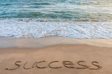 alphabet letters success handwritten in sand on beach