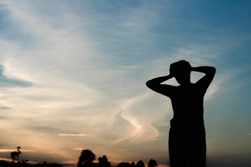 Silhouette of a Woman with Hands on Head