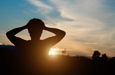 Silhouette of a Woman with Hands on Head