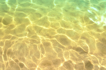 Close-up of shining sea water on gold sand beach. Koukounaries 