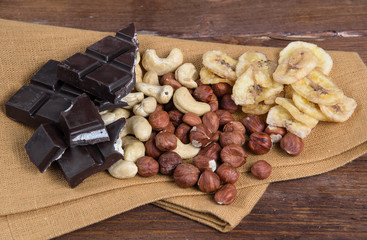 Chocolate and nuts with napkin on wood