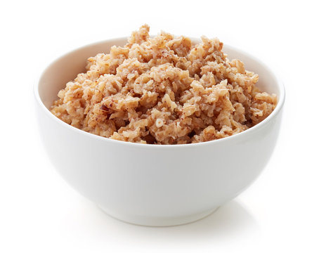 Bowl of buckwheat porridge isolated on white