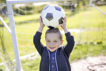 Naklejka premium boy with soccer ball in park