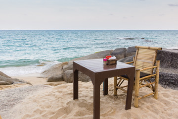 Table and chair on a rocky Thailand beach