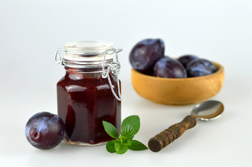 Jar of plum jam and fresh plums