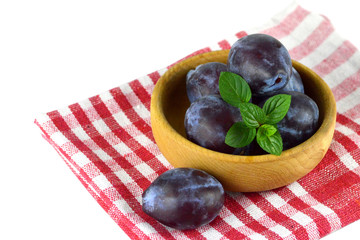 Plums in the wooden bowl
