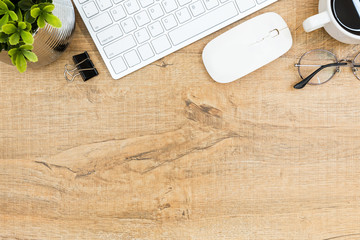 Wood desk table with computer gadgets and supplies. Top view wit