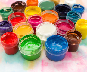 Paints, brushes and palette on the colorful background. The workplace of the artist. Banner for school