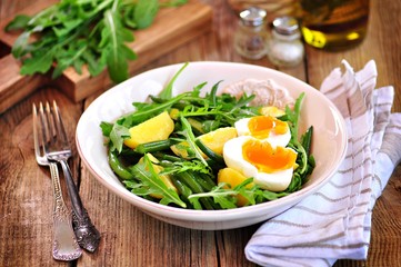 Vegetable salad with green beans, potatoes, arugula, eggs and olive oil. Vintage style.