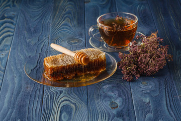 wildflower honey on wooden table next to honeycomb with honey di