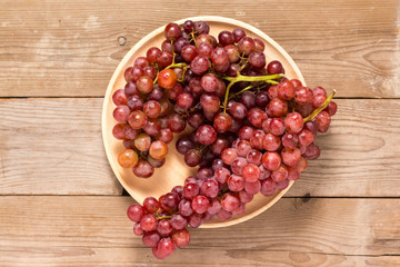 Red grapes on old wooden table