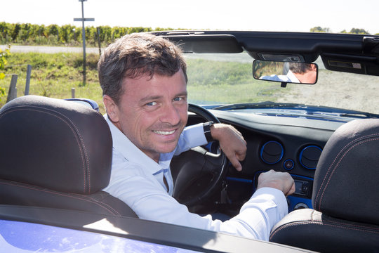 Man Happy In Blue Cabriolet Driving On Road Trip