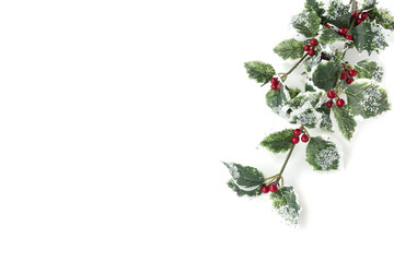 Artificial holly branch -  ilex aquifolium, with fruits, glass stones and glitter isolated on white background with copy space. 