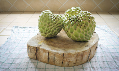 three custard apple or sugar apple on wood chopping block in kit