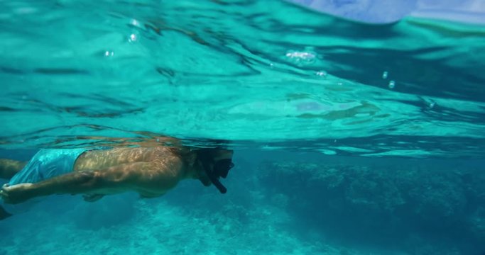 Man snorkeling underwater over tropical coral reef