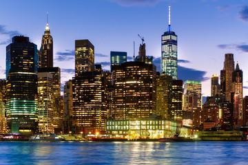 Fototapeta na wymiar Sunset in New York City with a view of the illuminated downtown Manhattan skyline